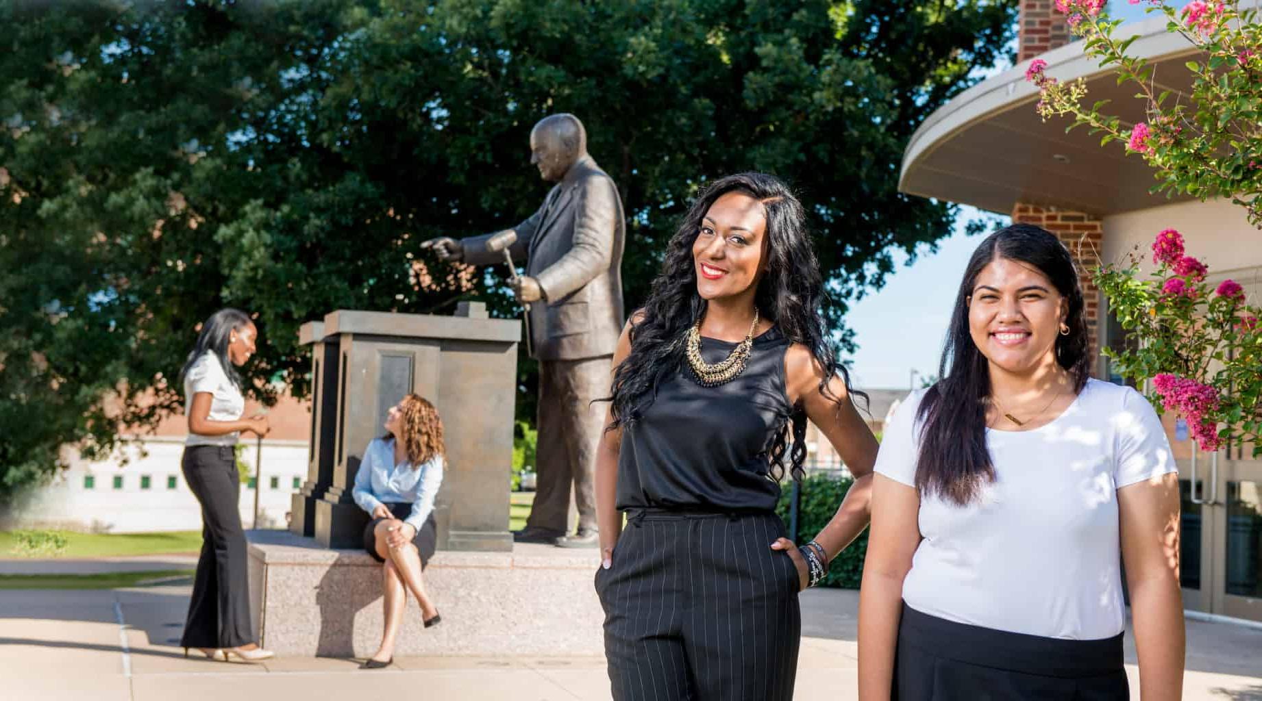 students outside student center smiling at the camera.