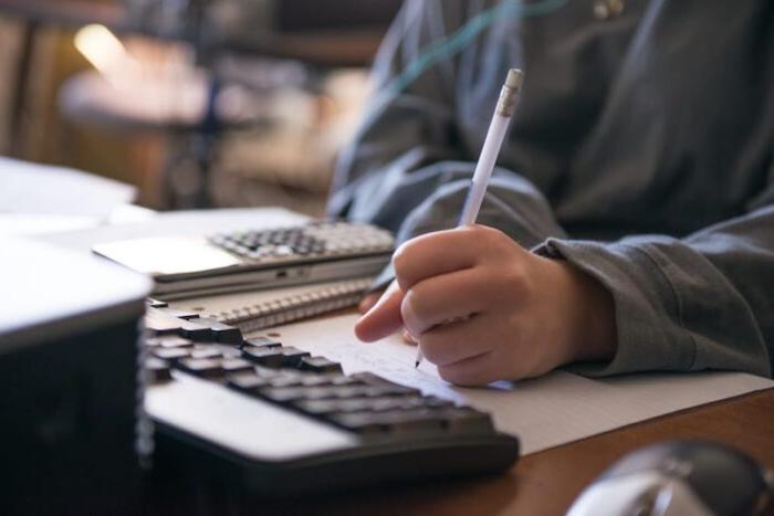 Math student writing in front of computer