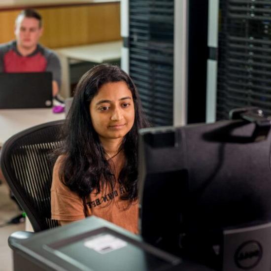 Computer science student looking at computer