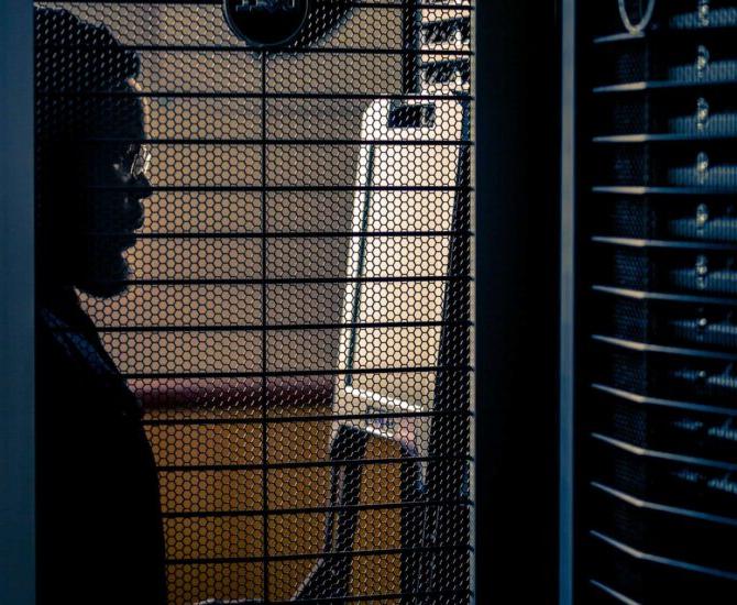 A male looking at a computer processing unit.