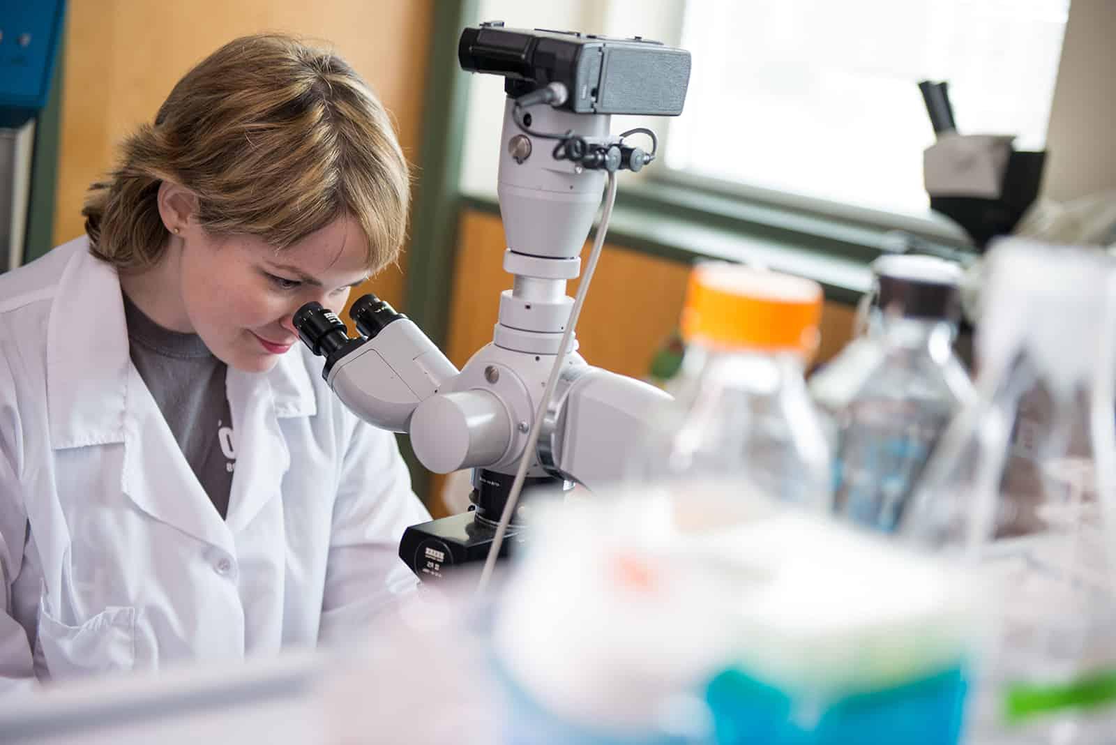 Student preforming lab experiment with a microscope.