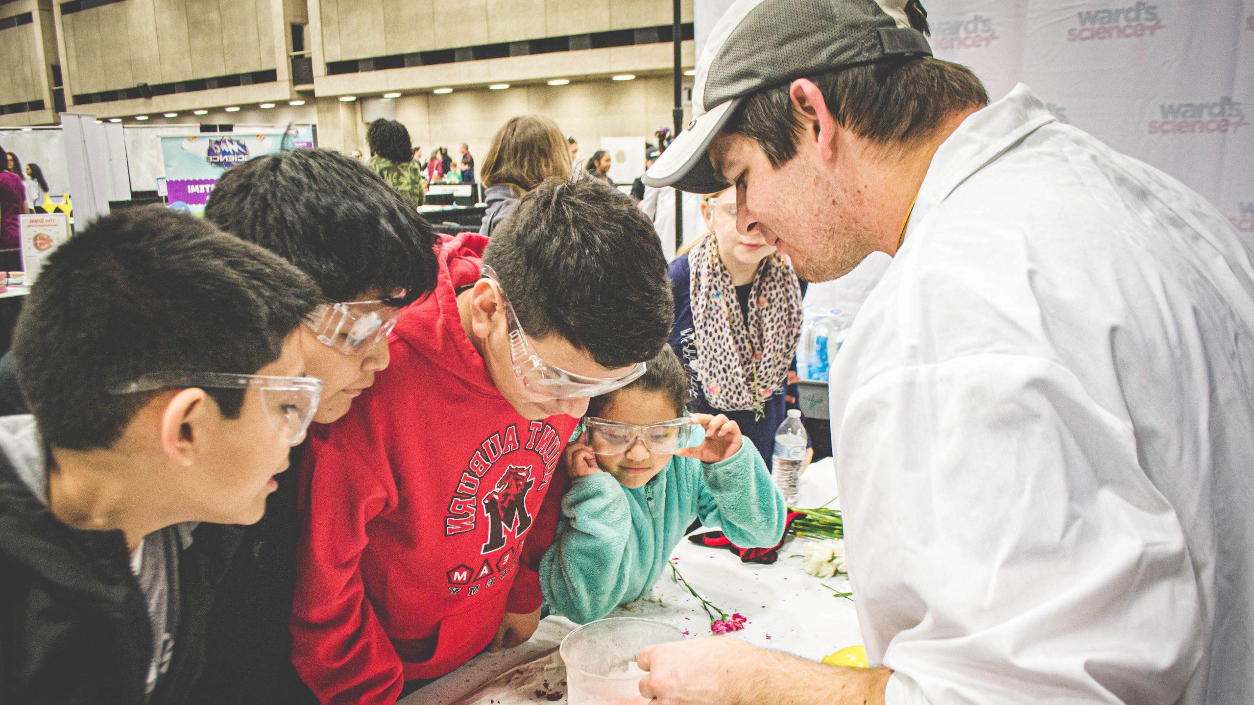 Students engaged in a science experiment that is being instructed by the instructor.