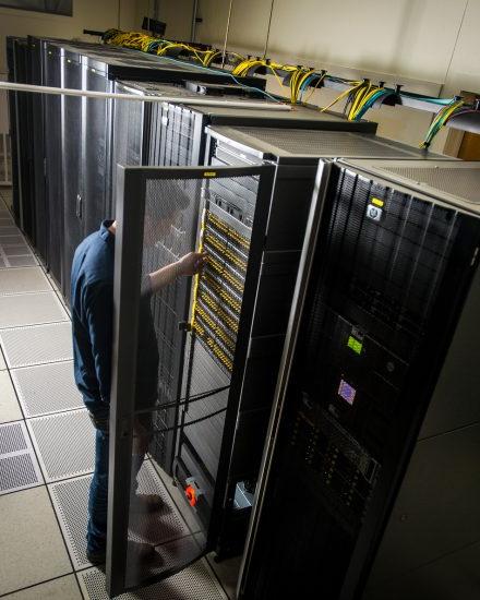 A male student checking computer circuits in a computer room.